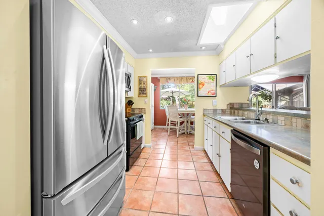 a kitchen with stainless steel appliances granite countertop a refrigerator and a stove top oven