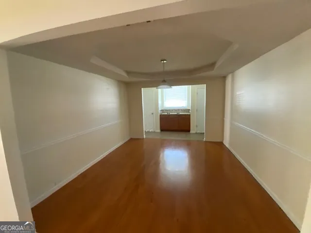 a view of empty room with wooden floor