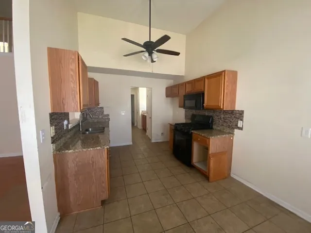 a kitchen with stainless steel appliances a sink a stove top oven a chimney and a window