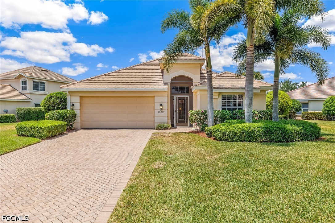 16969 Oakstead Drive Alva, FL 33920 - Photo 1 of 20 a view of a white house with a small yard and palm trees