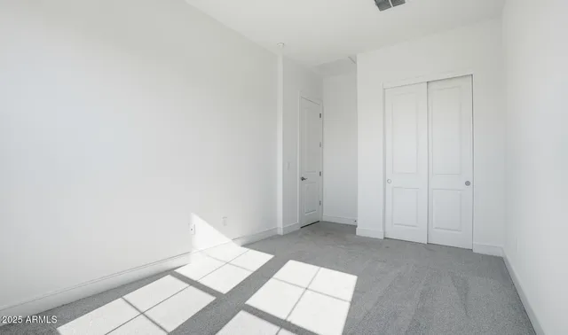 an empty room with windows and closet