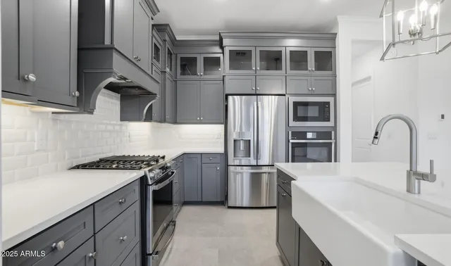 a kitchen with stainless steel appliances kitchen island granite countertop a refrigerator and a sink
