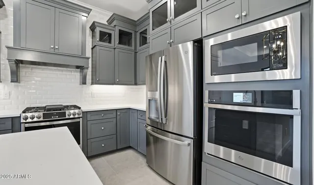a kitchen with stainless steel appliances granite countertop a refrigerator and a sink