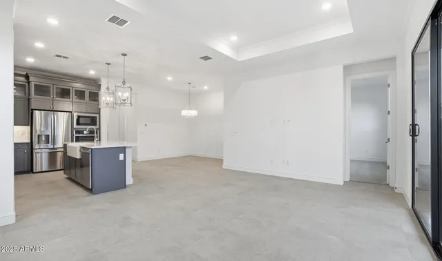 a view of a kitchen with a sink and dishwasher a refrigerator with wooden floor