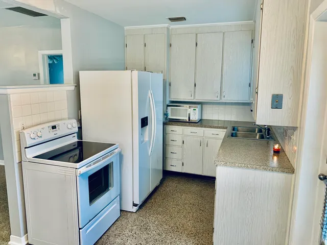 a kitchen with a refrigerator sink stove and cabinets