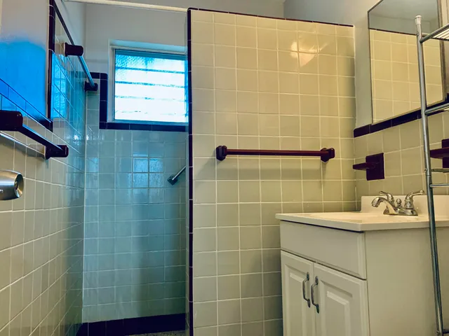 a bathroom with a sink shower and a mirror