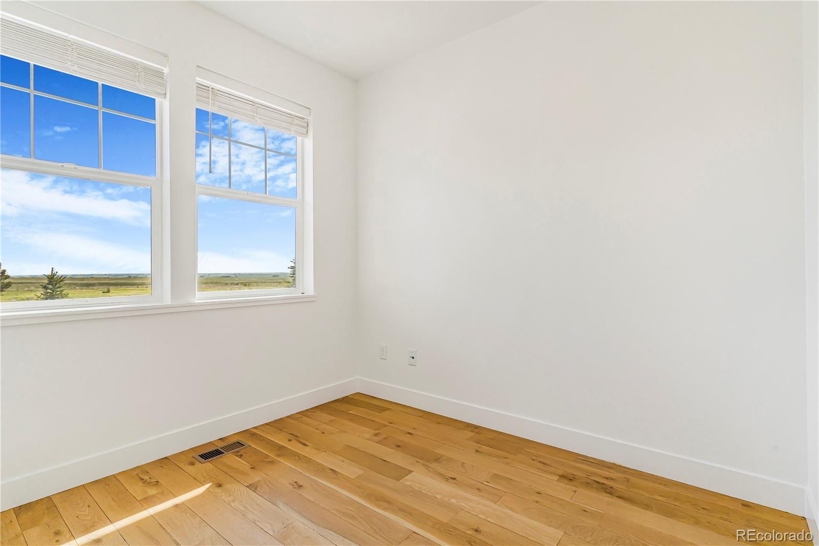 497 Valley Way Bennett, CO 80102 - Photo 12 of 37 a view of empty room with wooden floor and fan