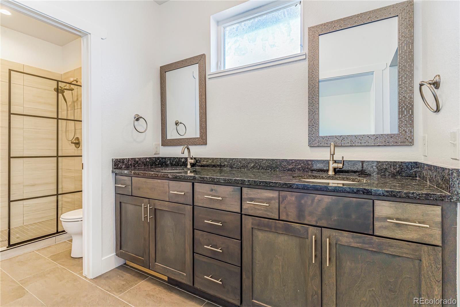 497 Valley Way Bennett, CO 80102 - Photo 16 of 37 a bathroom with a granite countertop sink and a mirror