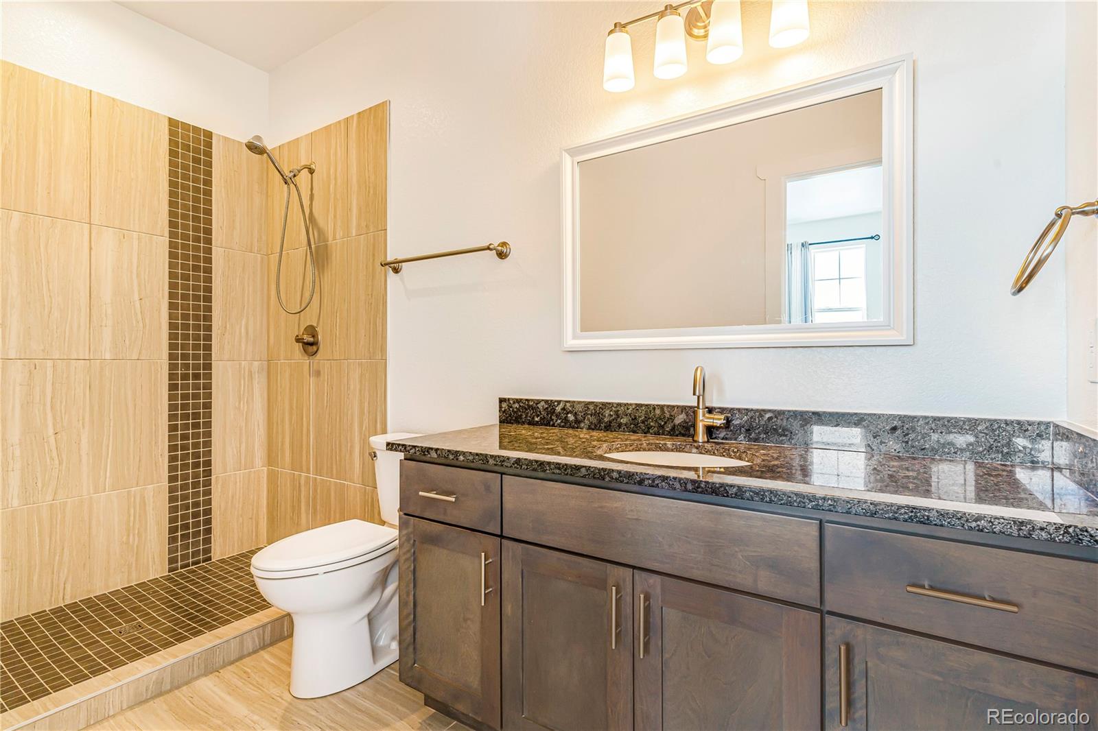497 Valley Way Bennett, CO 80102 - Photo 22 of 37 a bathroom with a sink a toilet and a mirror