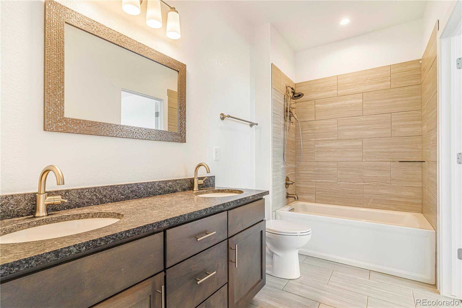 497 Valley Way Bennett, CO 80102 - Photo 26 of 37 a bathroom with a granite countertop sink a toilet and a bathtub