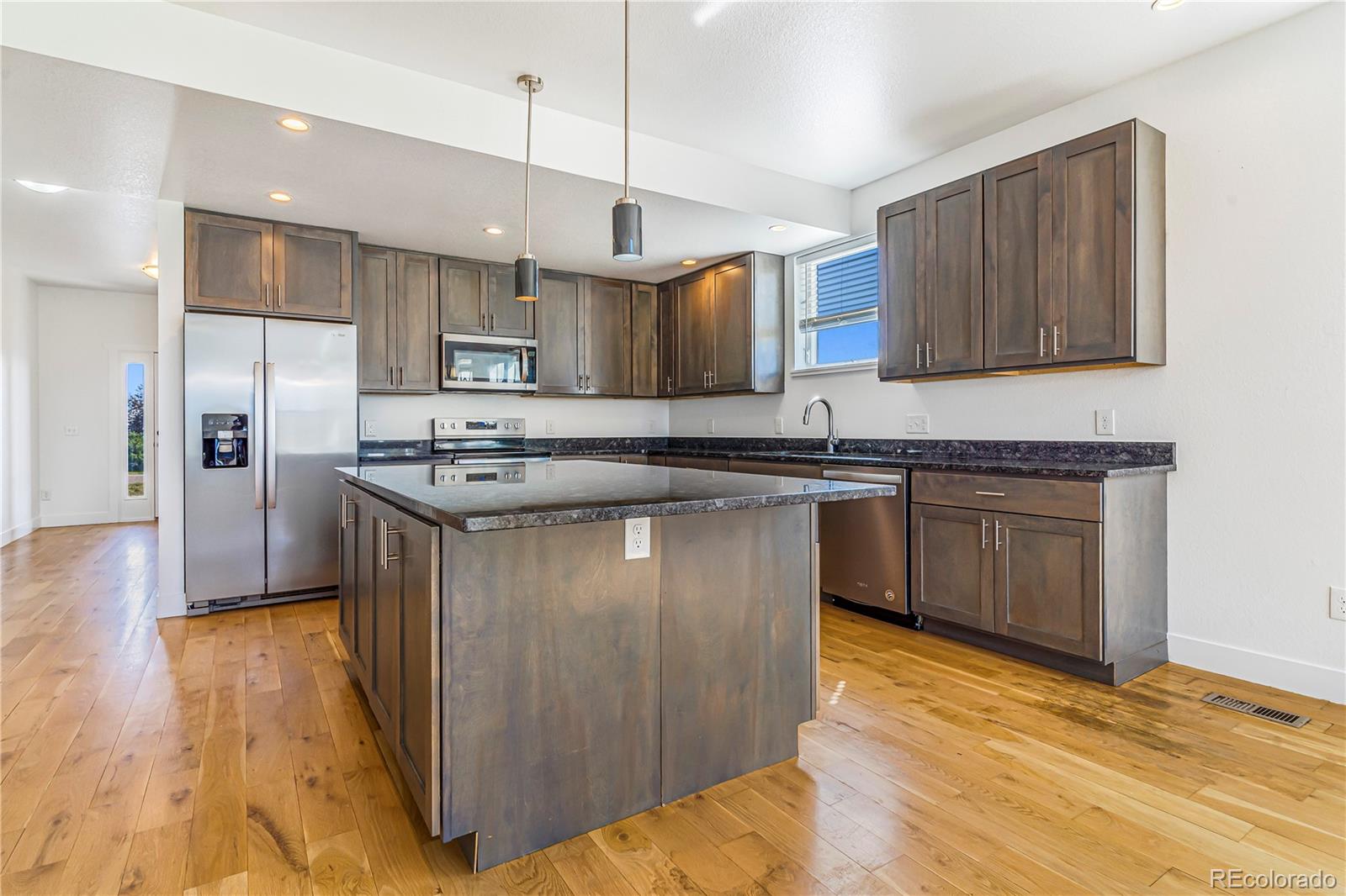 497 Valley Way Bennett, CO 80102 - Photo 3 of 37 a kitchen with stainless steel appliances granite countertop a stove a sink dishwasher a refrigerator and a wooden cabinets