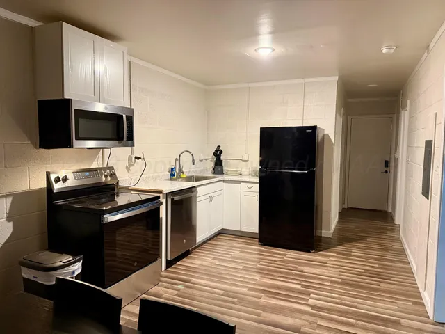 a kitchen with a refrigerator and a stove top oven