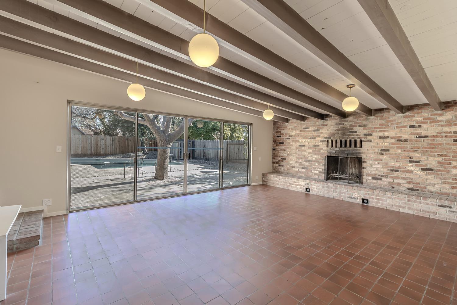 1506 Madison Avenue Tracy, CA 95376 - Photo 10 of 21 a view of an empty room with a fireplace and chandelier