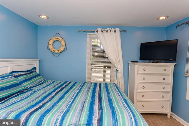 a view of a bedroom with wooden floor cabinet and a flat screen tv