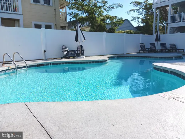 a view of backyard with swimming pool and outdoor seating