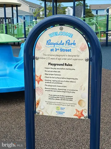 a couple of tables and chairs under an umbrella in front of house