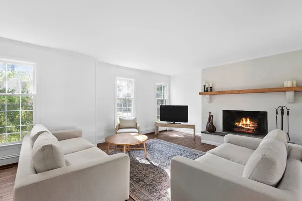 a living room with furniture a fireplace and a flat screen tv