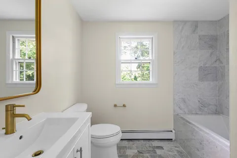 a bathroom with a sink a toilet and bathtub
