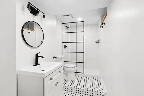 a bathroom with a sink a toilet and a mirror