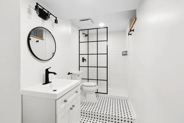 a bathroom with a sink a toilet and a mirror