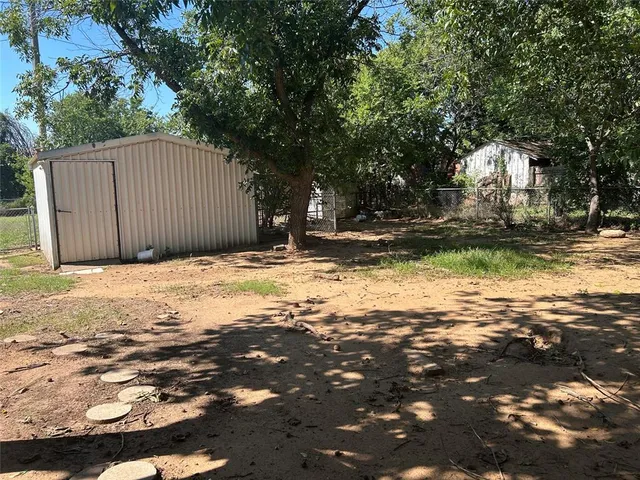 a view of a backyard with large trees