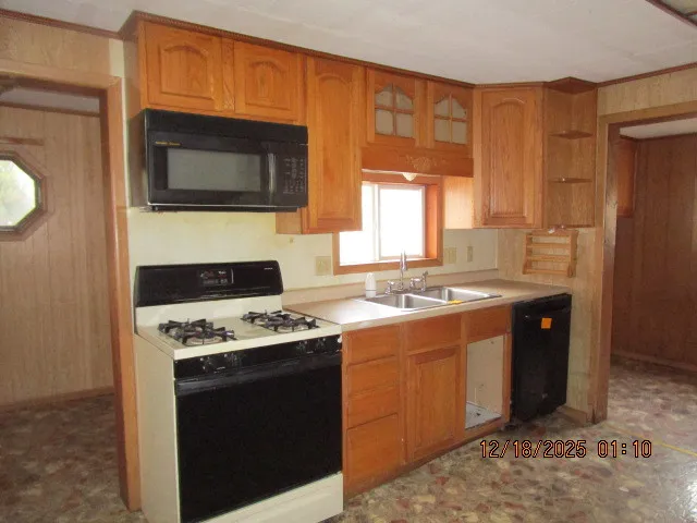 a kitchen with stainless steel appliances a stove a microwave and a sink