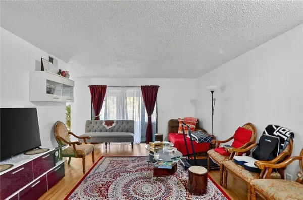 a living room with furniture a flat screen tv and a window