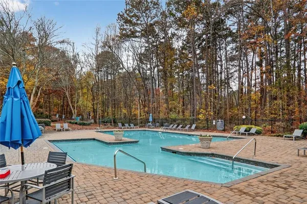 a swimming pool with outdoor seating and barbeque oven