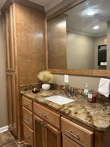 a bathroom with a granite countertop sink and a mirror