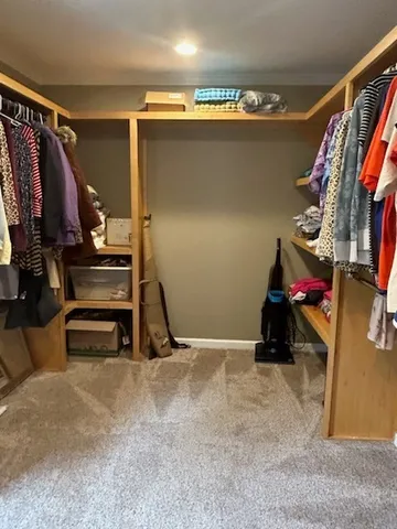 a view of walk in closet with clothes and shoes