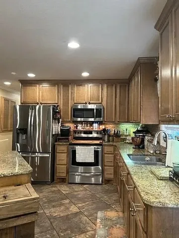 a kitchen with refrigerator a sink and a counter top space