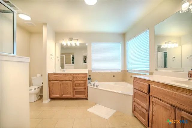 a bathroom with a tub sink and mirror