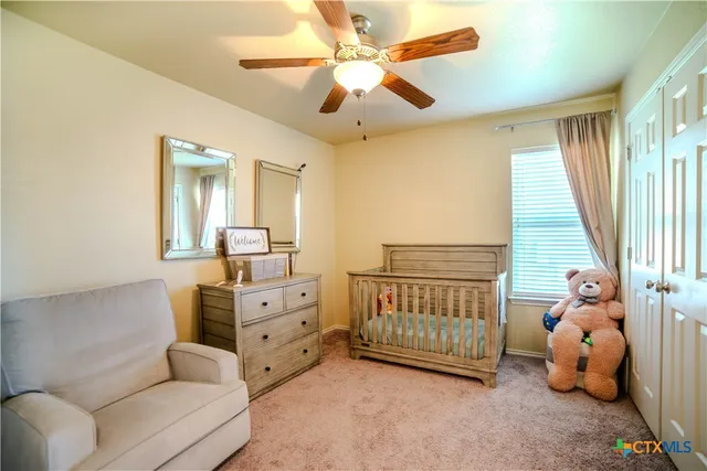 a spacious bedroom with a bed and a chandelier