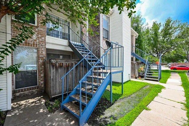 a view of house with wooden stairs and a yard