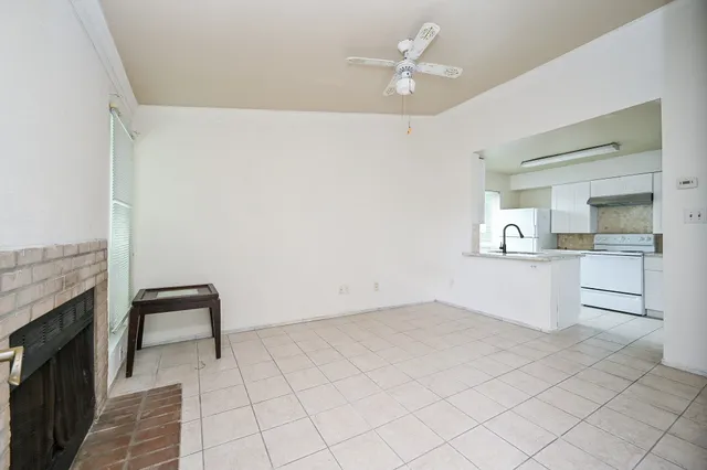 a view of kitchen with refrigerator and white cabinets