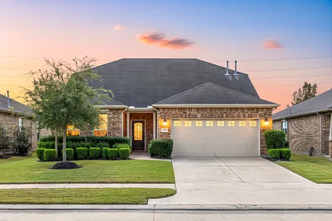 a front view of a house with a yard and potted plants