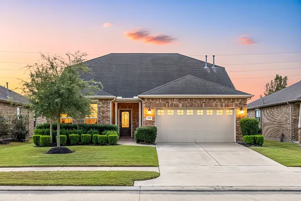 a front view of a house with a yard and potted plants