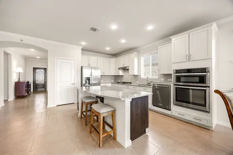 a open kitchen with kitchen island a sink table and chairs