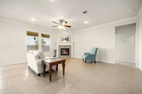a living room with furniture kitchen view and a chandelier