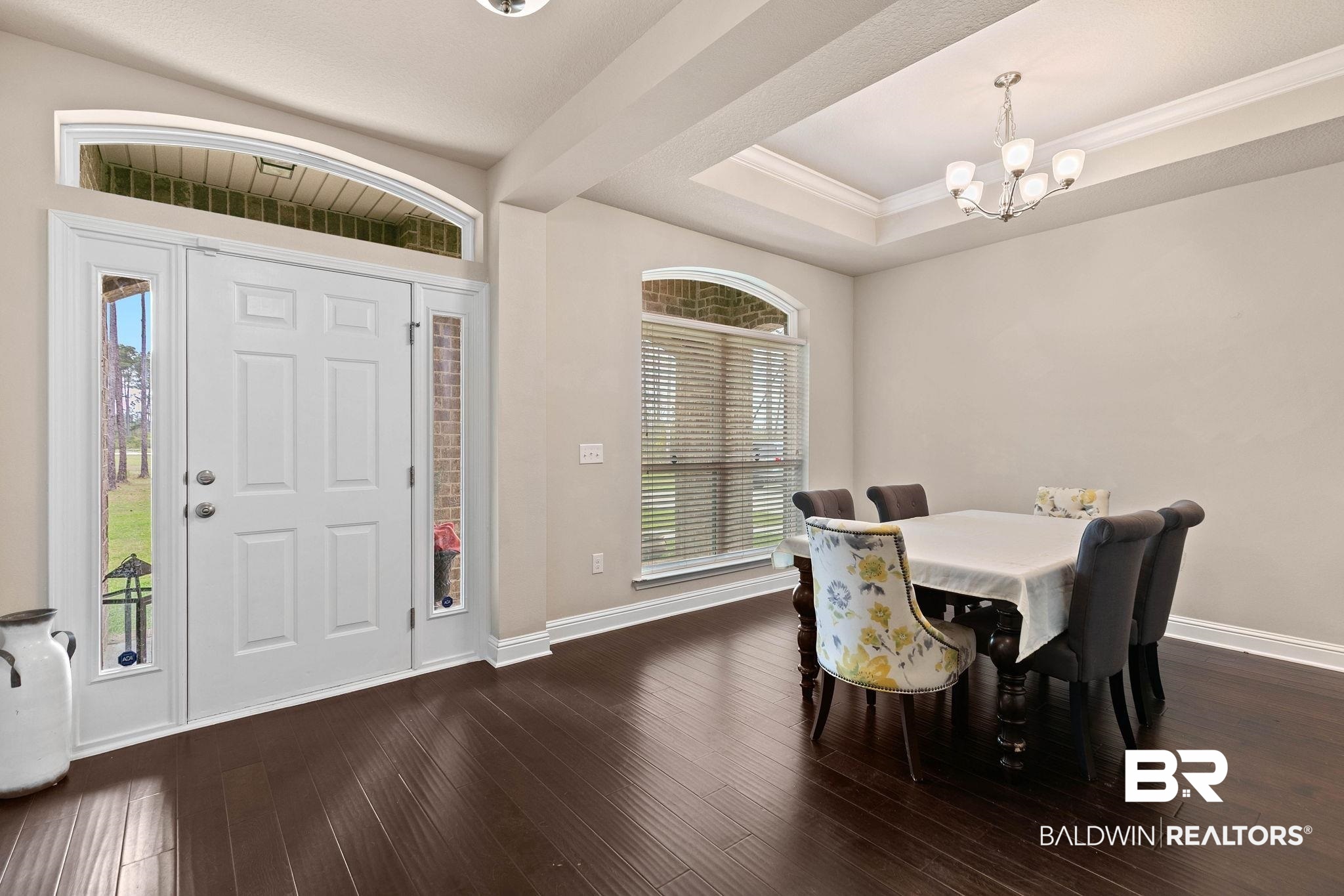 12750 B Jenkins Pit Road Daphne, AL 36527 - Photo 7 of 89 Dining area featuring a raised ceiling, ornamental molding, dark wood-style flooring, and a chandelier