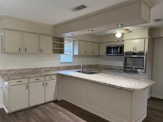 a view of empty room with wooden floor and stove