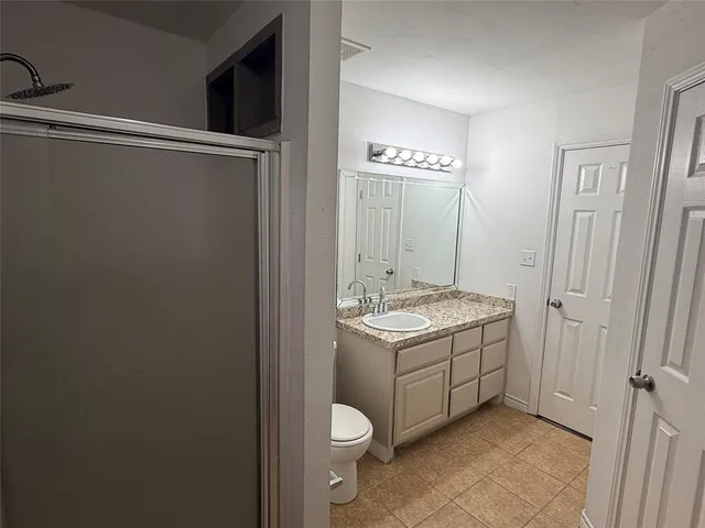 a view of a room with wooden floor and a chandelier fan