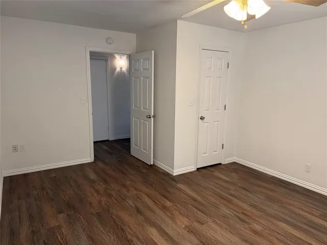 an empty room with a window and wooden floor