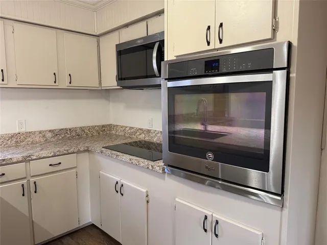 a kitchen with stainless steel appliances granite countertop white cabinets and sink