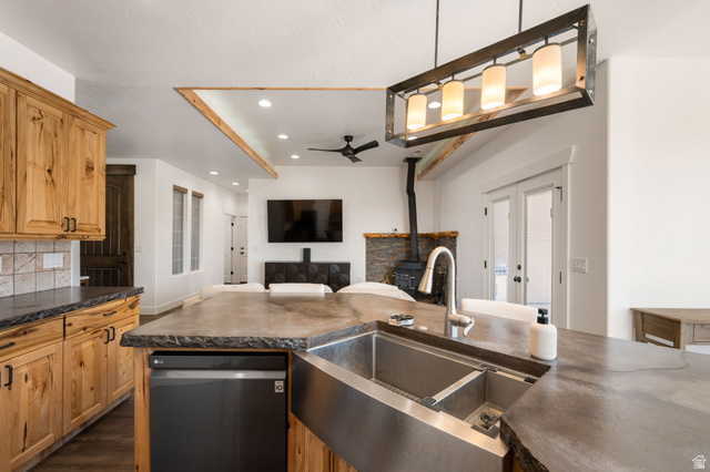 62 North Lucky 7 Road Veyo, UT 84782 - Photo 42 of 43 Kitchen featuring open floor plan, dishwashing machine, a wood stove, a ceiling fan, and backsplash