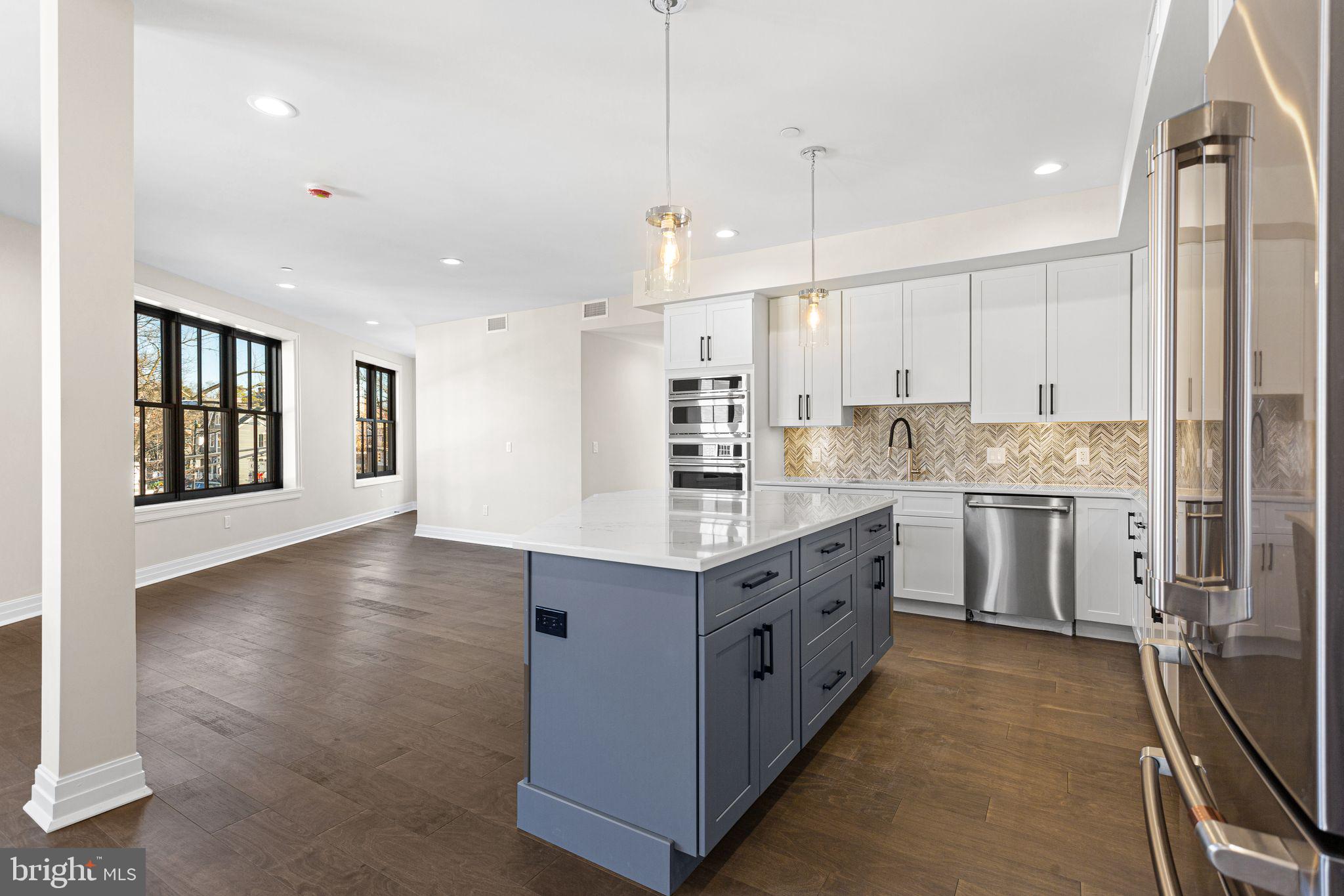 151 Kings Highway East, Unit B Haddonfield, NJ 08033 - Photo 2 of 23 a kitchen with stainless steel appliances granite countertop a stove a sink a refrigerator and white cabinets with wooden floor