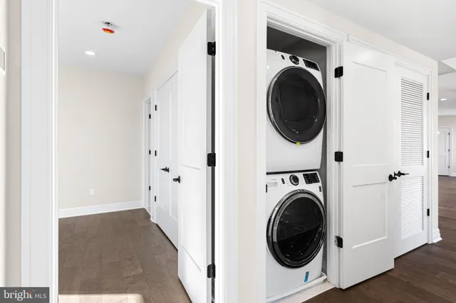 a view of a hallway with wooden floor and a large mirror
