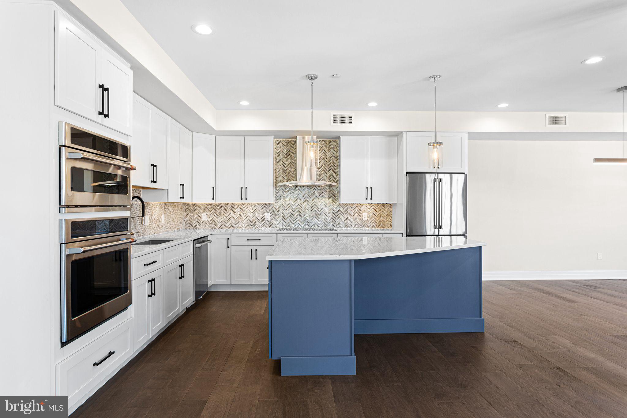 151 Kings Highway East, Unit B Haddonfield, NJ 08033 - Photo 4 of 23 a kitchen with stainless steel appliances granite countertop a sink a stove a refrigerator and island with wooden floor