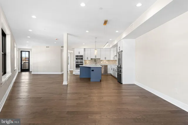 a view of kitchen with kitchen island refrigerator sink and cabinets