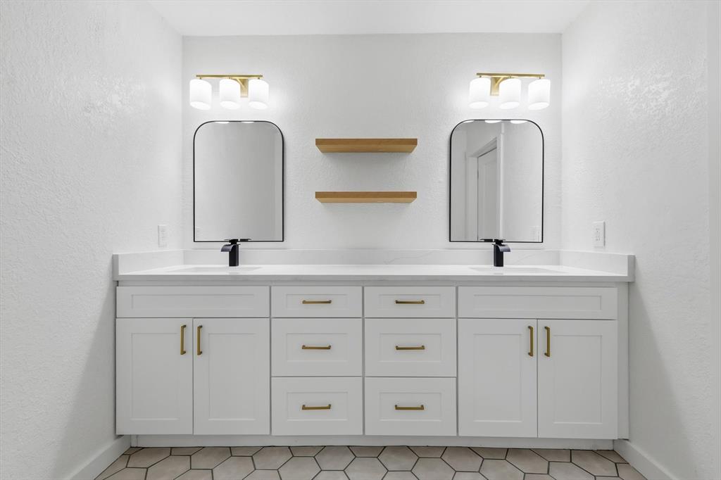 5940 Hunters View Lane Dallas, TX 75232 - Photo 11 of 24 Full bath with a textured wall, double vanity, and light tile patterned floors